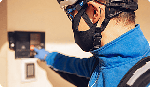 Electrician wearing protective gear installing wiring in a residential or commercial building.