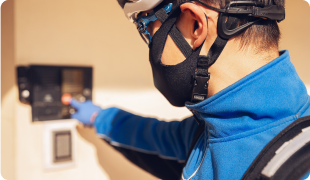 Electrician wearing protective gear installing wiring in a residential or commercial building.